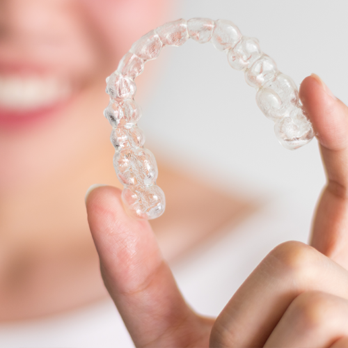 Invisalign Reviews - Invisalign being held by a person