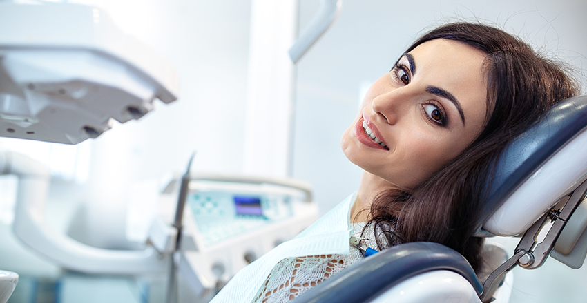A very beautiful woman laying in a dental bed