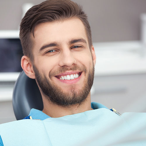 Pretty men in a dental bed with super white teeth