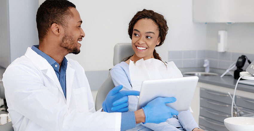 Dentist showing her patient with her dental symptoms