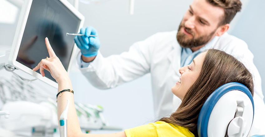 Dentist discussing the dental result of his patient in a dental monitor