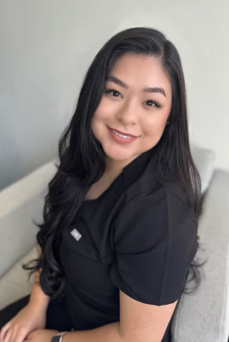 A woman in a black shirt sitting on a couch.